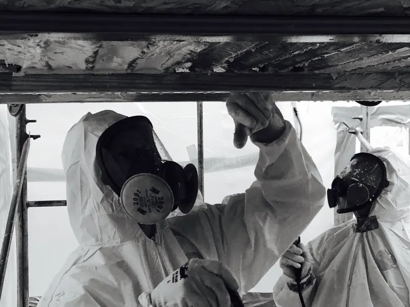 Asbestos abatement workers in protective suits and respirators
