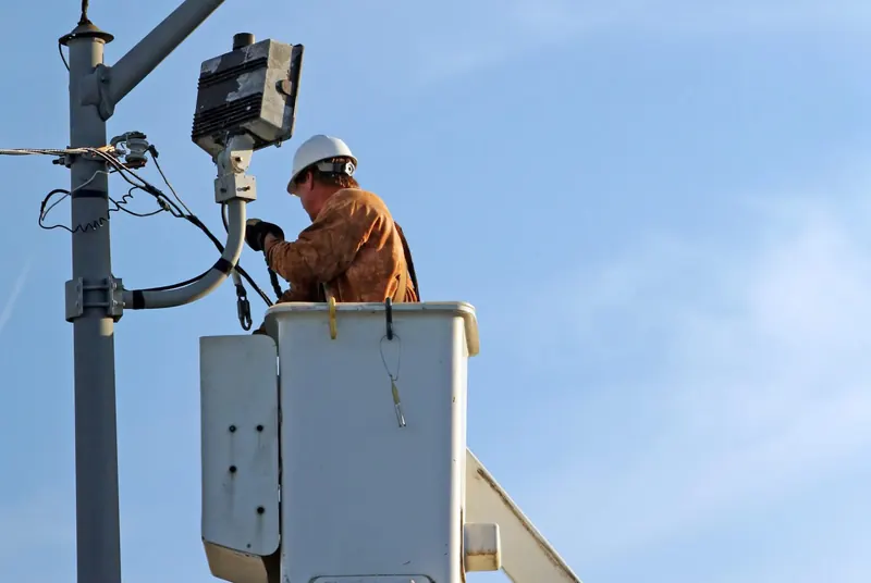 A line worker in the bucket of a truck-mounted aerial device