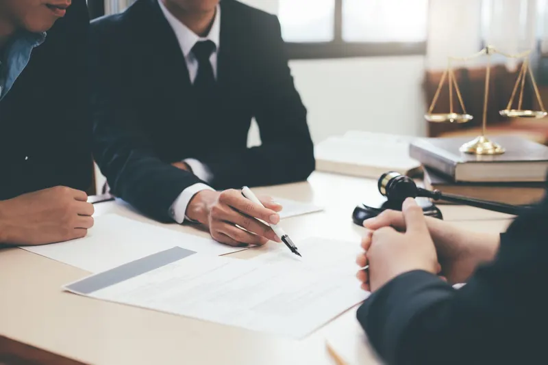 Legal documents being signed beside a gavel