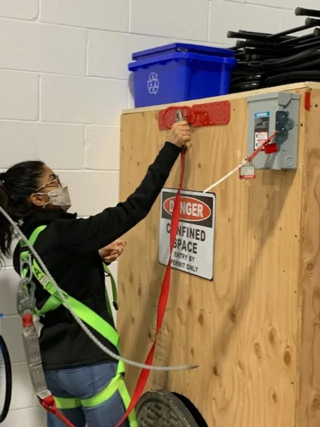 A trainee applying a lockout to an electrical disconnect