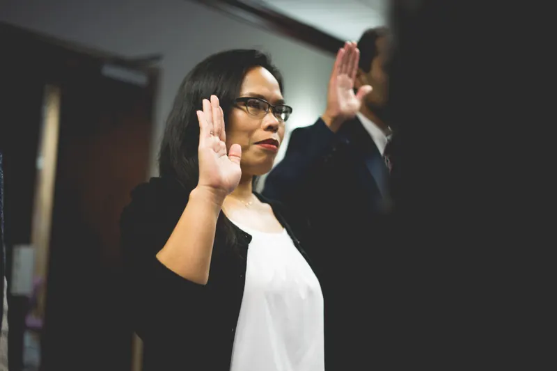 A woman raising her right hand to take an oath