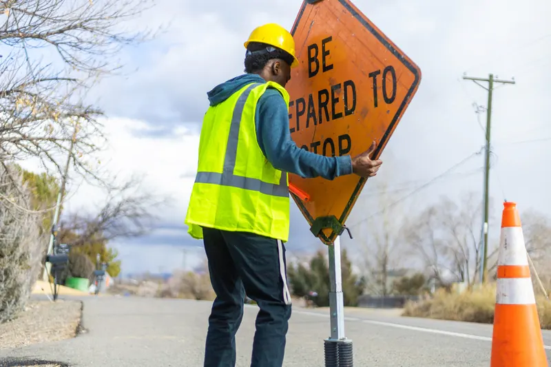A traffic control person holding a stop sign on a road